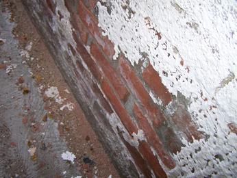 Peeling paint on a foundation or white powdery resiude (effluourescence) indicate areas where dampness comes and goes or exists more frequently.  A moisture meter is used to determine the dampness on the day of the inspection, but whether it is dry or not, the inspector will advise you of various courses of action.  Even if dry that day, dampness can reoccur.  This situation is mos common in older basements which are more prone to moisture penetration, as with this brick foundation.